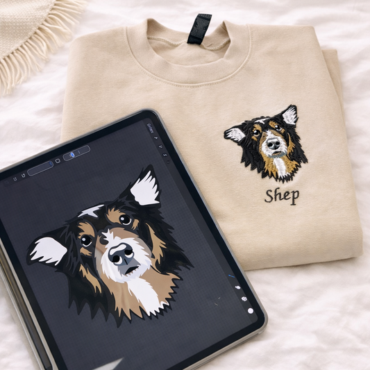 Beige sweatshirt with embroidered dog design and 'Shep' text, next to a tablet displaying the same design.